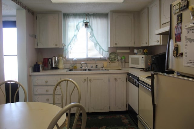 kitchen featuring white cabinetry, sink, and white appliances