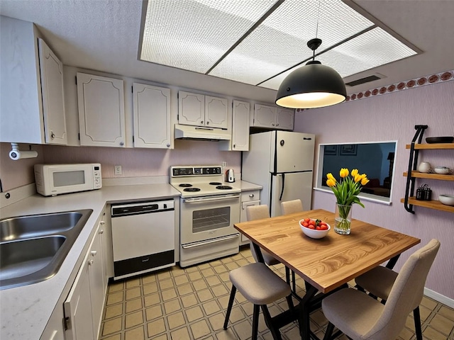 3682 Lake Bayshore Dr Unit K402, Bradenton, FL 34205 - kitchen with white appliances, under cabinet range hood, light countertops, and decorative light fixtures