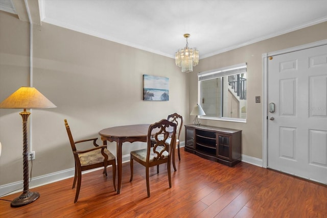 dining room with dark hardwood / wood-style flooring, an inviting chandelier, and crown molding