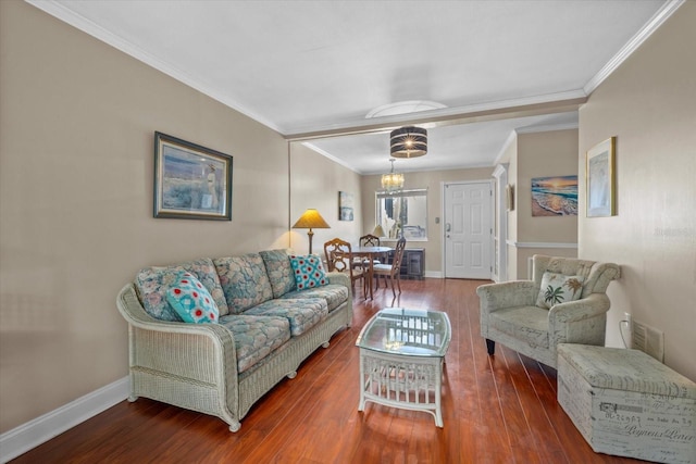 living room featuring ornamental molding, dark wood-type flooring, and an inviting chandelier