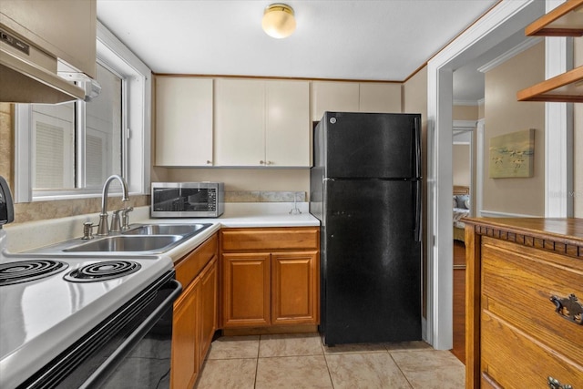 kitchen featuring black appliances, a wealth of natural light, crown molding, and sink