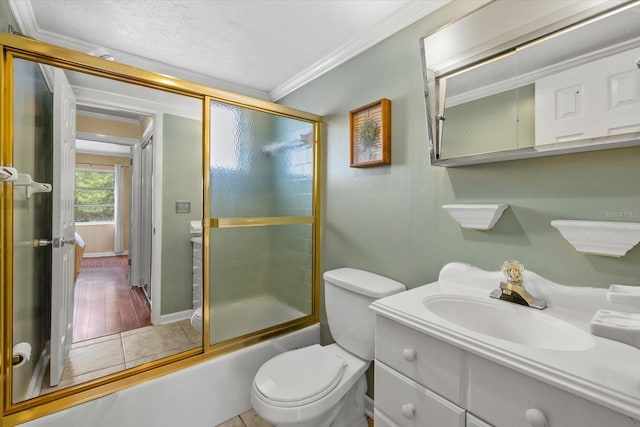 full bathroom with tile patterned flooring, combined bath / shower with glass door, ornamental molding, toilet, and vanity