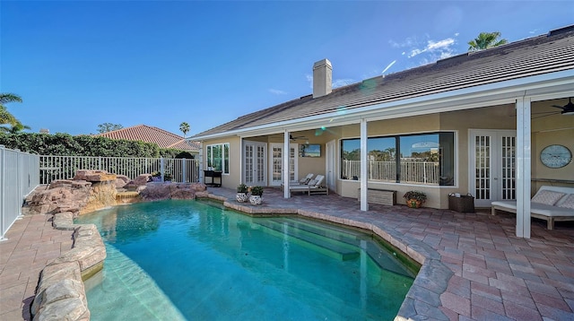 view of pool with french doors, ceiling fan, and a patio