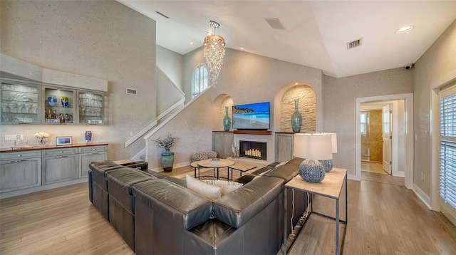 living room with light wood-type flooring and high vaulted ceiling