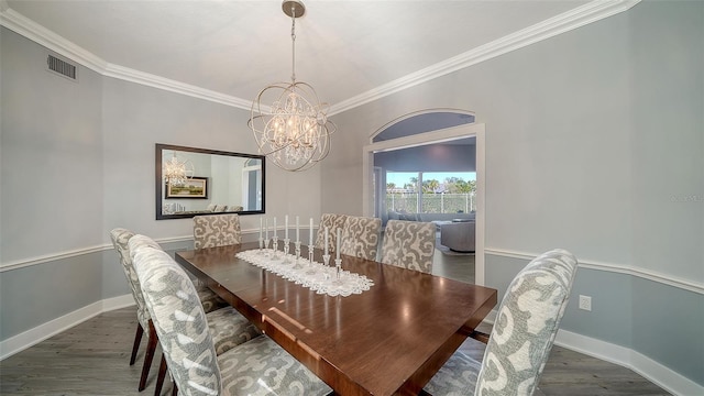 dining room featuring crown molding, dark hardwood / wood-style floors, and a chandelier