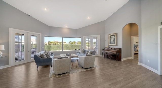 living room featuring french doors, high vaulted ceiling, and light hardwood / wood-style flooring