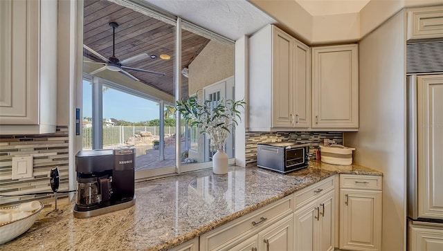 kitchen with backsplash, light stone countertops, and ceiling fan