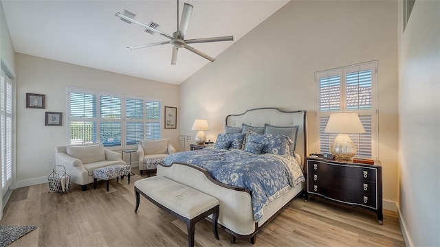 bedroom with ceiling fan, wood-type flooring, high vaulted ceiling, and multiple windows