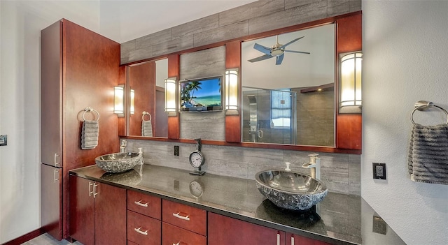 bathroom featuring ceiling fan, vanity, a shower with shower door, and backsplash