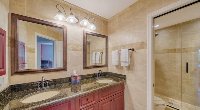 bathroom featuring vanity, an enclosed shower, and tile walls