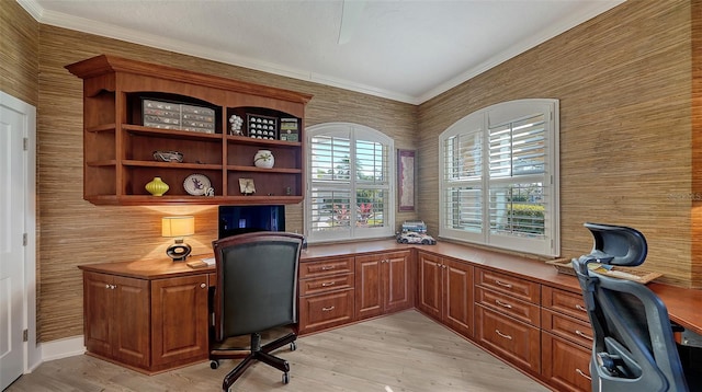 office with light hardwood / wood-style flooring, crown molding, and built in desk