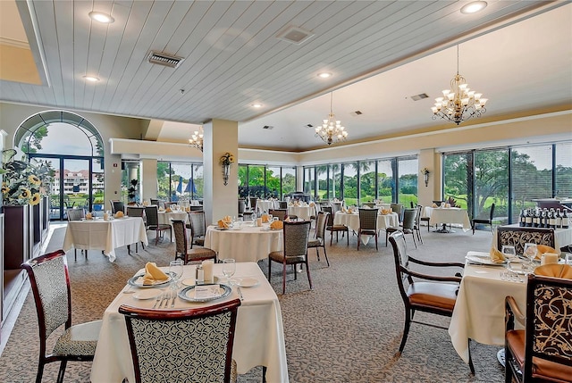 carpeted dining area with a notable chandelier, wood ceiling, and a wealth of natural light