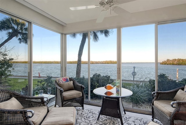 sunroom featuring plenty of natural light, ceiling fan, and a water view