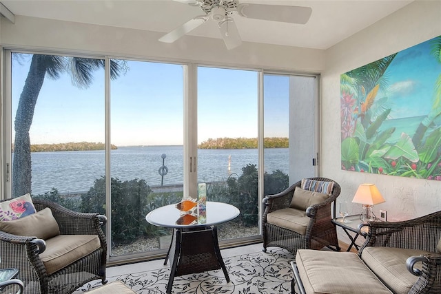 sunroom / solarium with ceiling fan and a water view