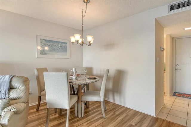 dining area featuring a chandelier and light hardwood / wood-style flooring