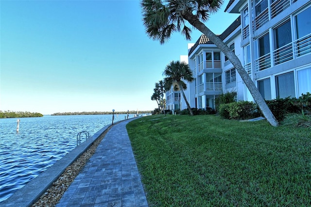 view of property's community featuring a yard and a water view