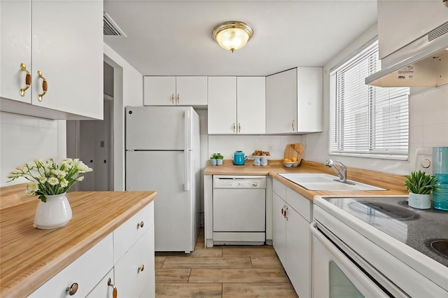 kitchen with extractor fan, tasteful backsplash, sink, white cabinets, and white appliances