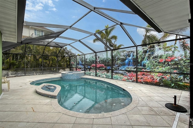 view of pool featuring glass enclosure, an in ground hot tub, and a patio