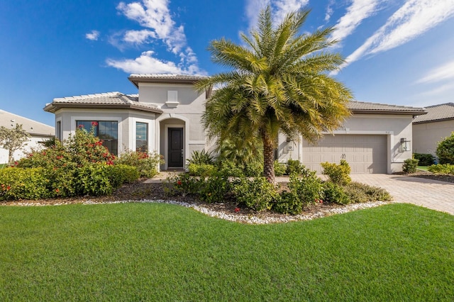 mediterranean / spanish-style house with a garage and a front lawn