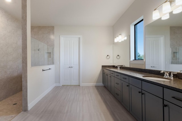 bathroom with tiled shower and vanity