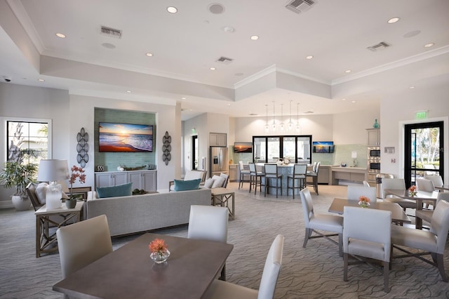 dining space with a raised ceiling, carpet, and a chandelier