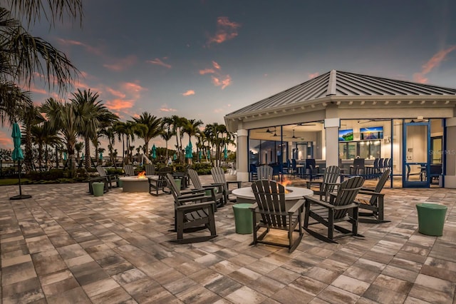 patio terrace at dusk with a fire pit and ceiling fan