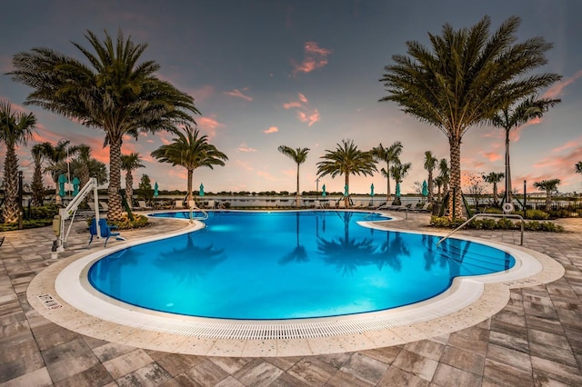 pool at dusk with a patio