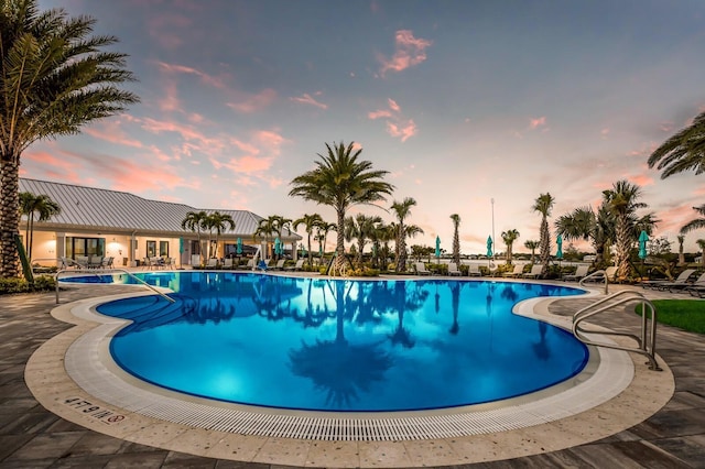 pool at dusk featuring a patio