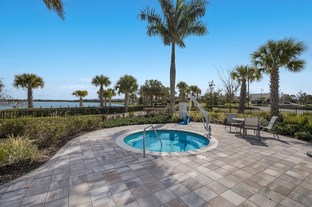 view of swimming pool featuring a water view, a hot tub, and a patio