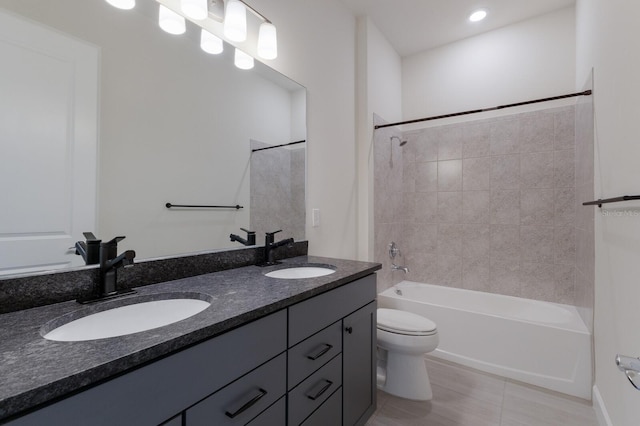 full bathroom with vanity, tile patterned flooring, tiled shower / bath combo, and toilet