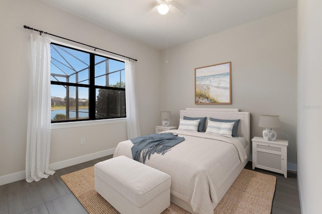 bedroom featuring ceiling fan and a water view