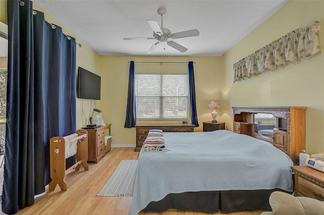 bedroom featuring a textured ceiling, ceiling fan, and light hardwood / wood-style flooring