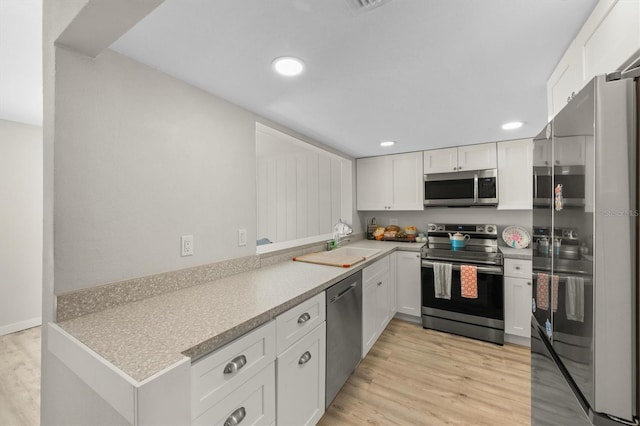 kitchen featuring stainless steel appliances, light hardwood / wood-style flooring, white cabinets, and sink