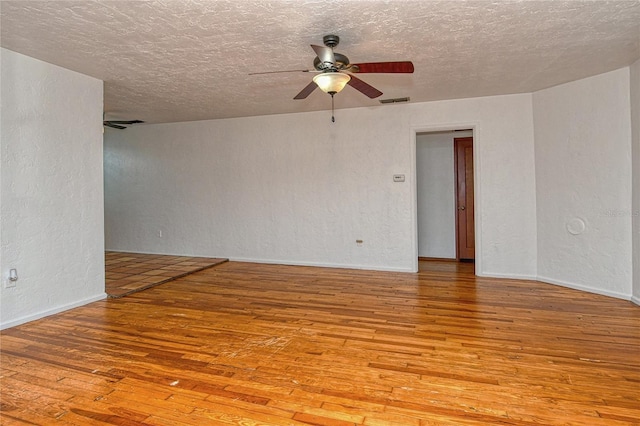 empty room with ceiling fan, a textured ceiling, and light wood-type flooring