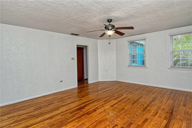 empty room with ceiling fan, a textured ceiling, and hardwood / wood-style flooring