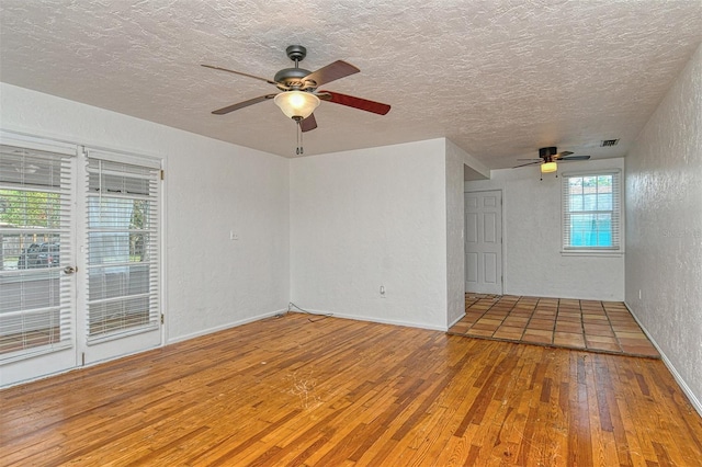 empty room featuring a textured ceiling, ceiling fan, and hardwood / wood-style floors