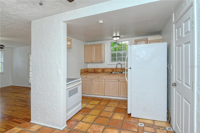 kitchen featuring a textured ceiling, sink, light brown cabinets, and white appliances