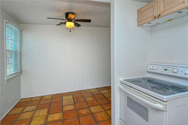 kitchen featuring white range with electric cooktop, light brown cabinetry, and a textured ceiling