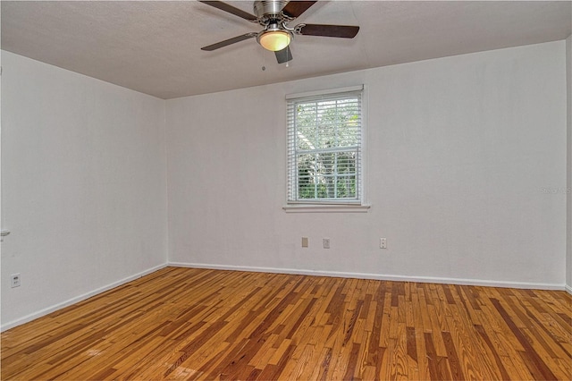 spare room with hardwood / wood-style flooring and ceiling fan