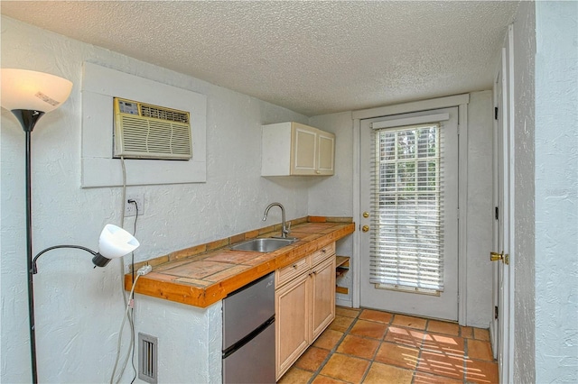 kitchen featuring an AC wall unit, a textured ceiling, butcher block counters, sink, and light tile patterned flooring