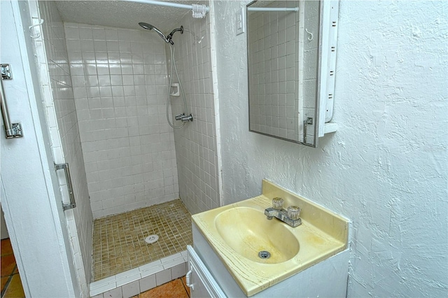 bathroom with vanity and tiled shower