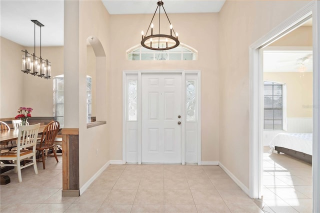 tiled entrance foyer featuring a notable chandelier