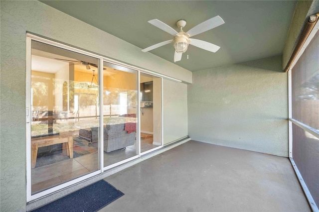 unfurnished sunroom with ceiling fan