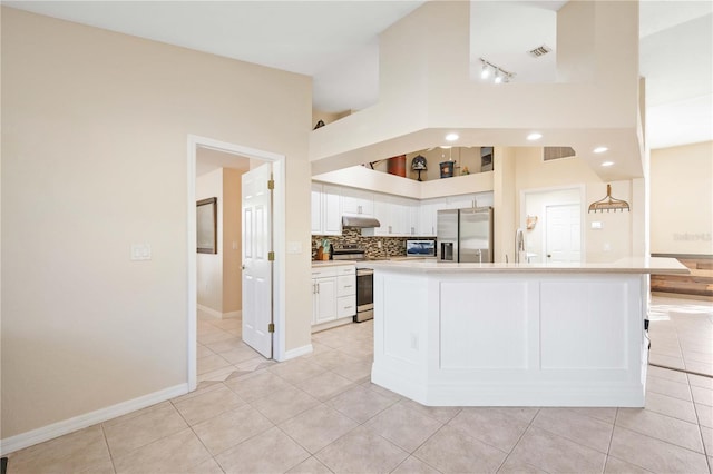 kitchen featuring light tile patterned floors, appliances with stainless steel finishes, white cabinetry, a center island, and decorative backsplash