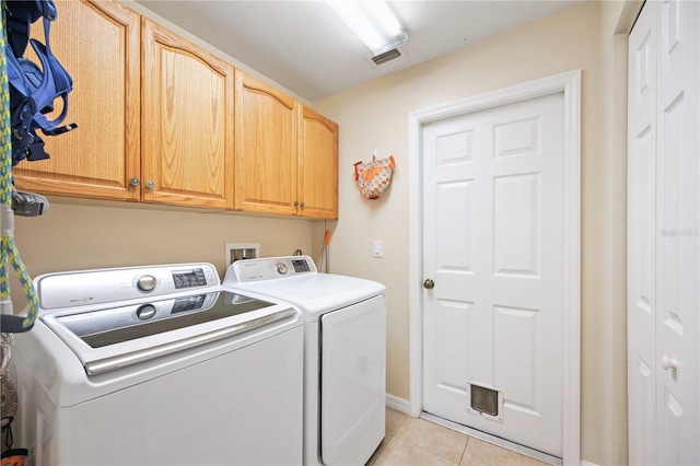 laundry room featuring cabinets, washer and dryer, and light tile patterned floors