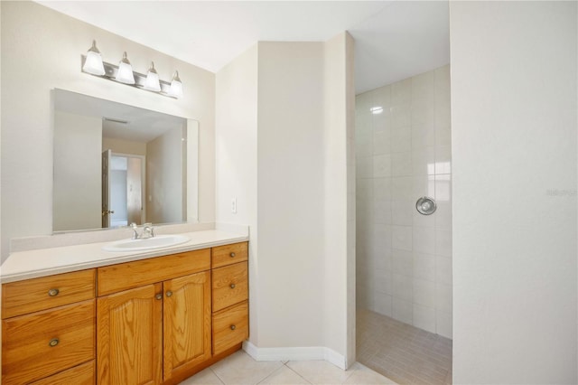 bathroom with tile patterned floors, vanity, and a tile shower