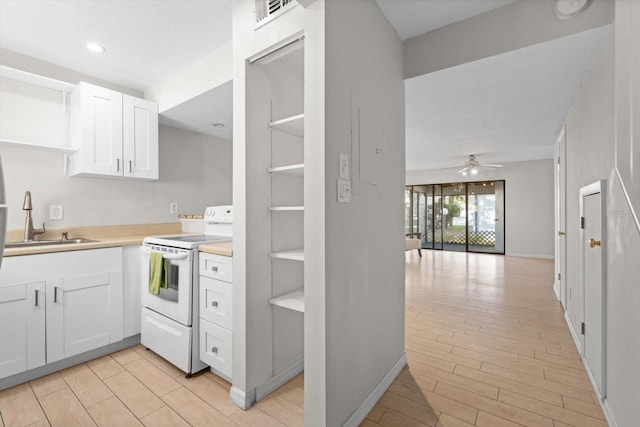 kitchen featuring white electric stove, open shelves, visible vents, white cabinetry, and a sink