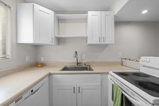 kitchen with open shelves, light countertops, white cabinets, a sink, and white appliances