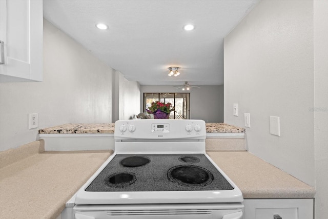 kitchen featuring light countertops, recessed lighting, white range with electric stovetop, and white cabinets