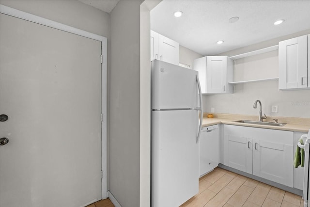 kitchen with open shelves, white appliances, a sink, and white cabinets